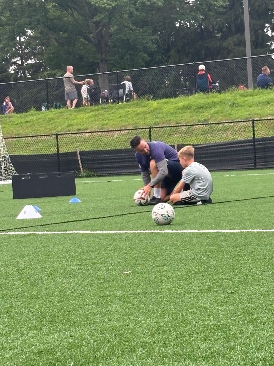 Apex coach working one-on-one with a young soccer player during training